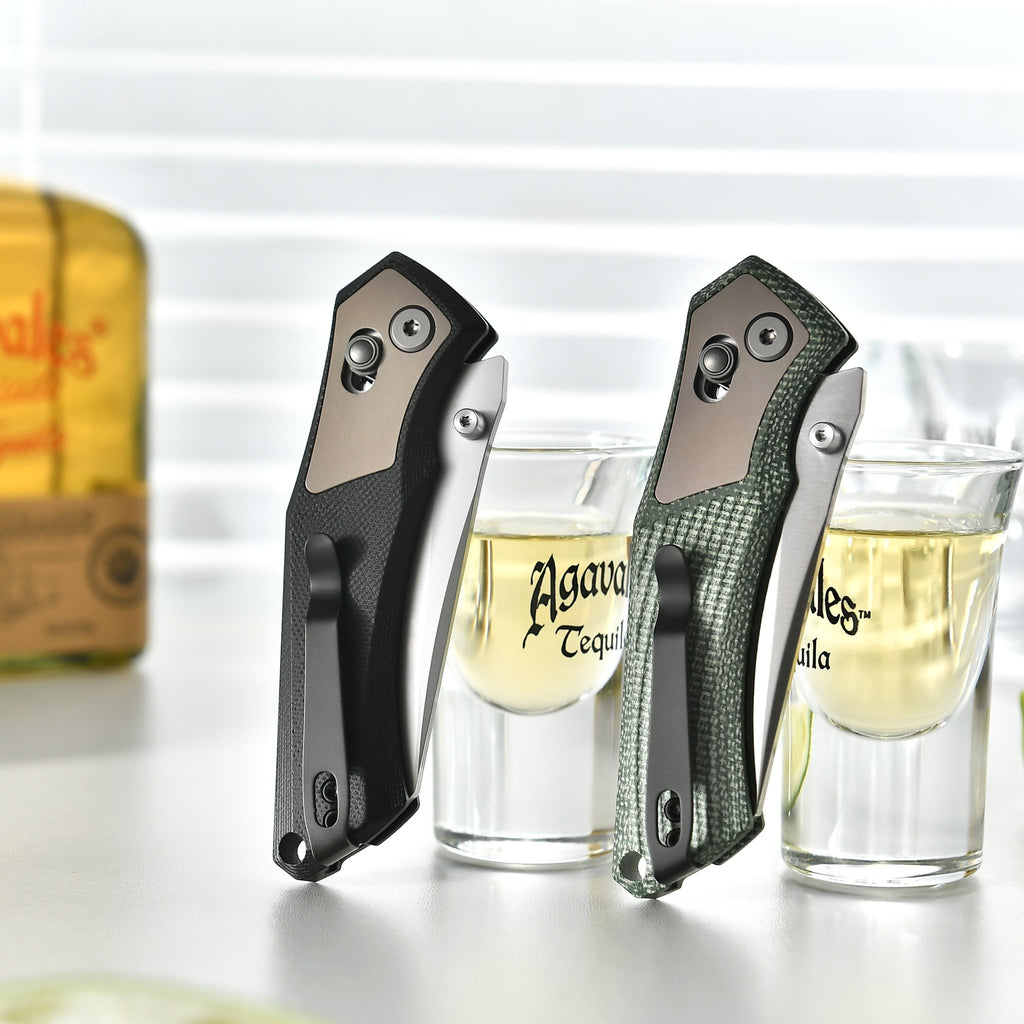 Two knives with shot glasses of tequila on a table next to a bottle of tequila.