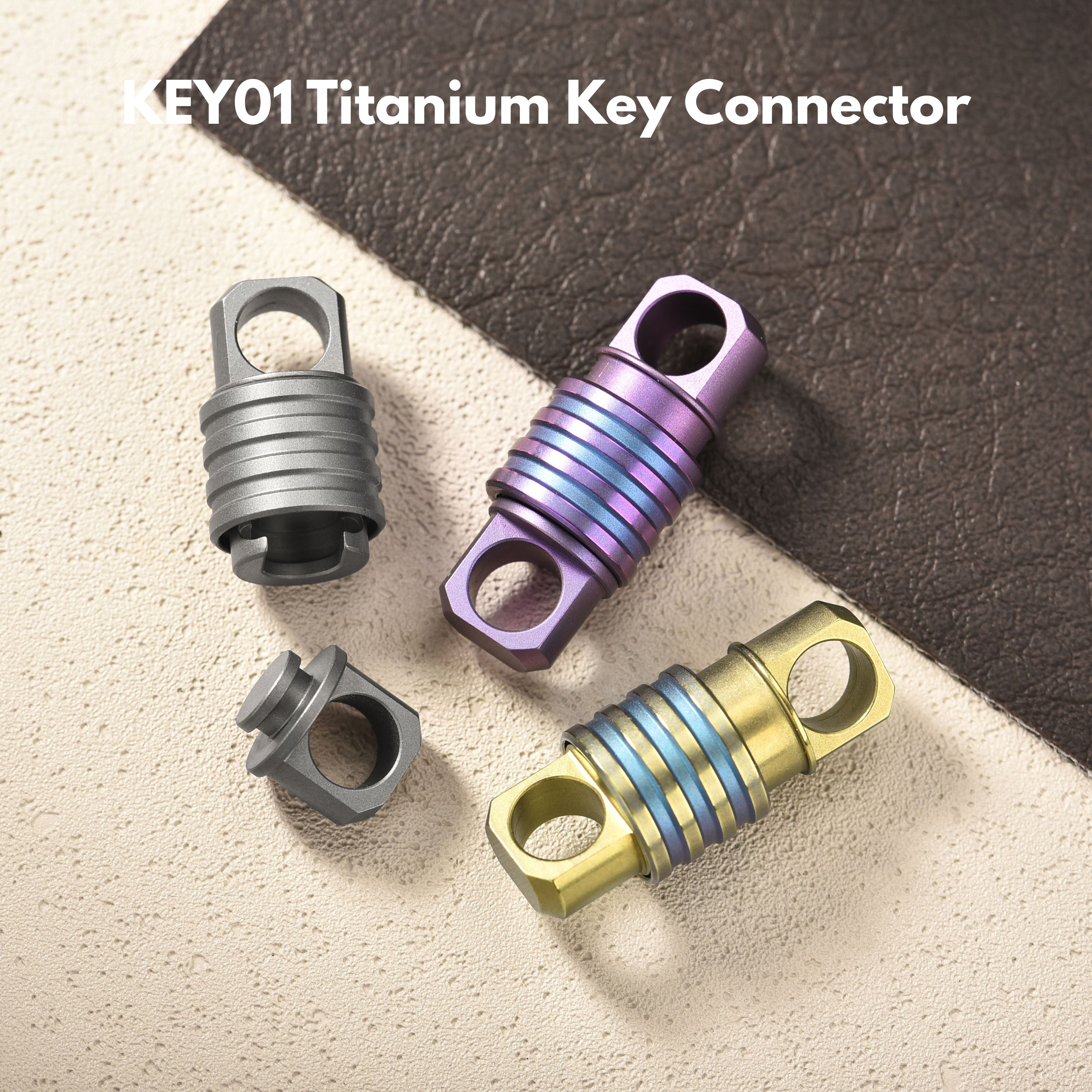 Tacray titanium key connectors in gray, purple, and gold on a textured surface.